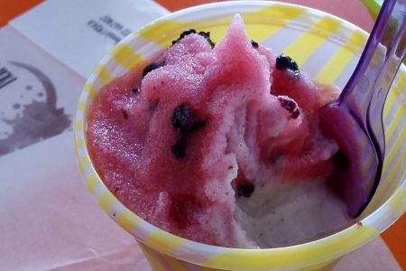 granita siciliana alla mandorla e gelsi, color crema e fucsia, servita in bicchiere di plastica