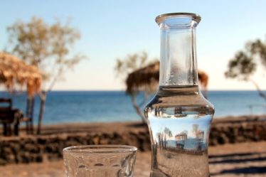 bottiglitta tsipouro grecia su tavolo con sfondo del mare